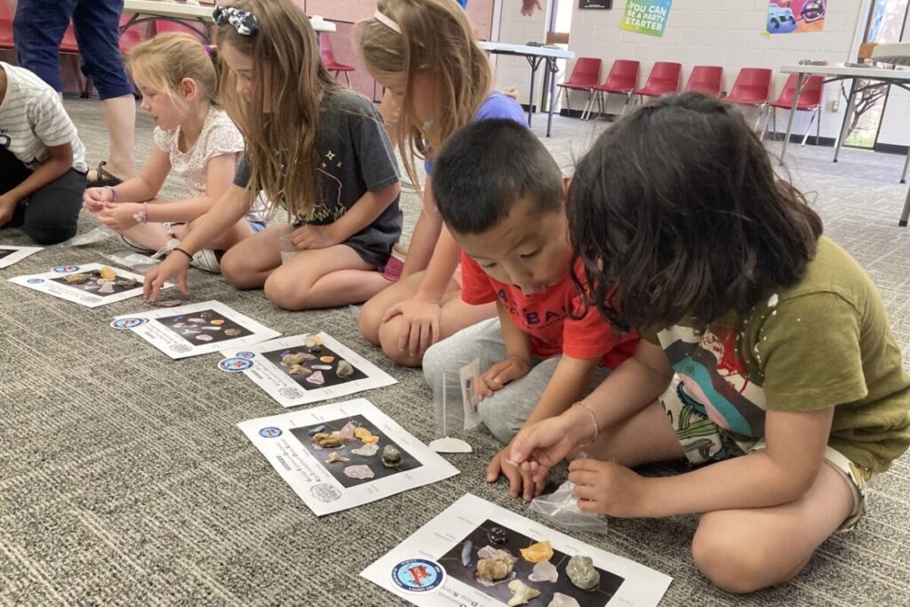 Children participating in a GeoKIDS Earth science education activity while exploring rocks and minerals through hands-on geoscience learning and science experiments.